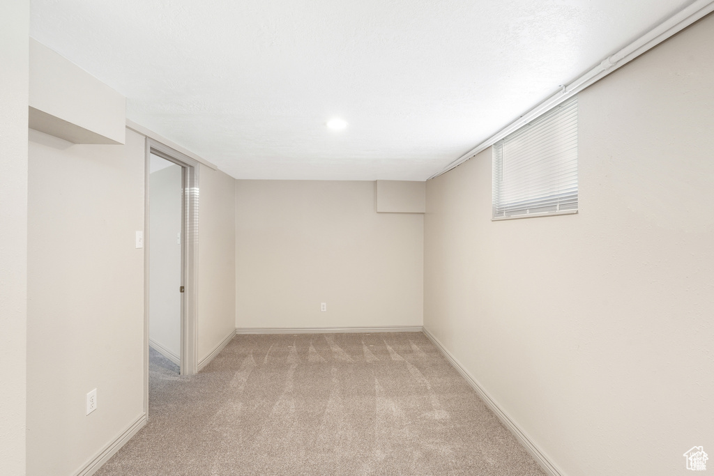 Finished basement with baseboards and light carpet