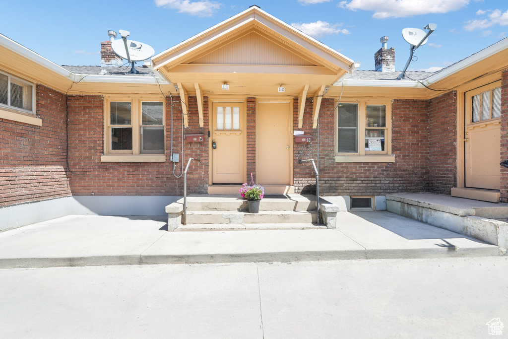 Entrance to property featuring brick siding and a chimney