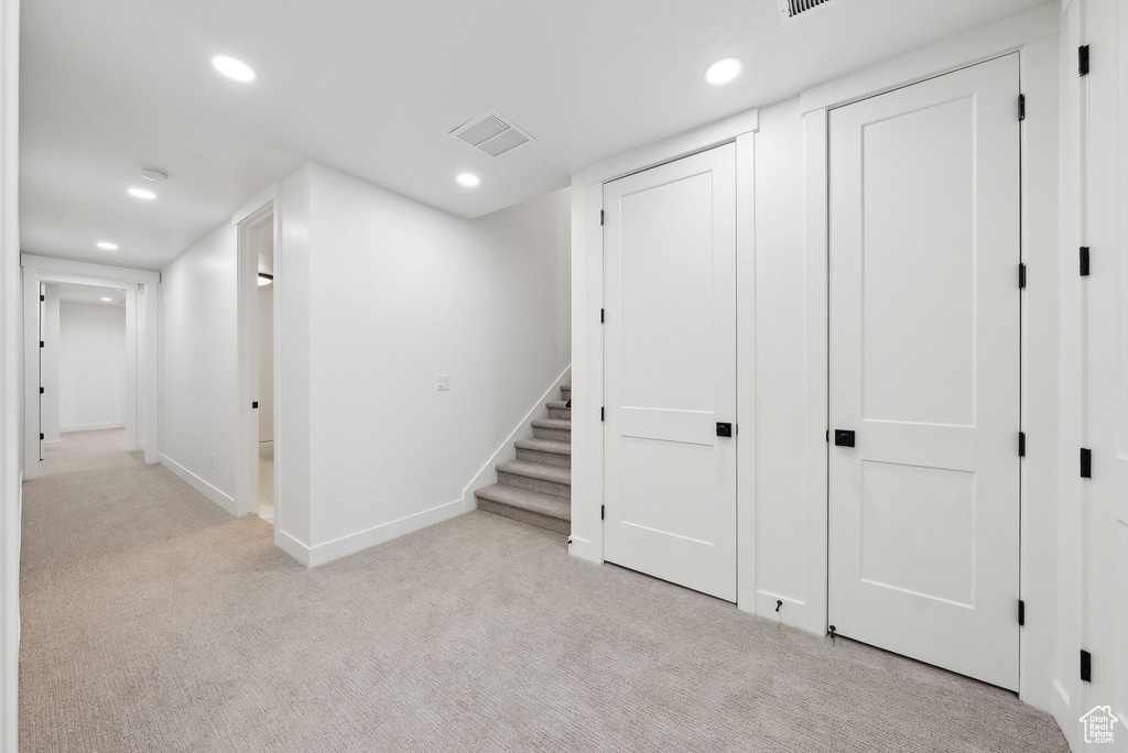 Finished basement with light colored carpet, recessed lighting, baseboards, and stairs