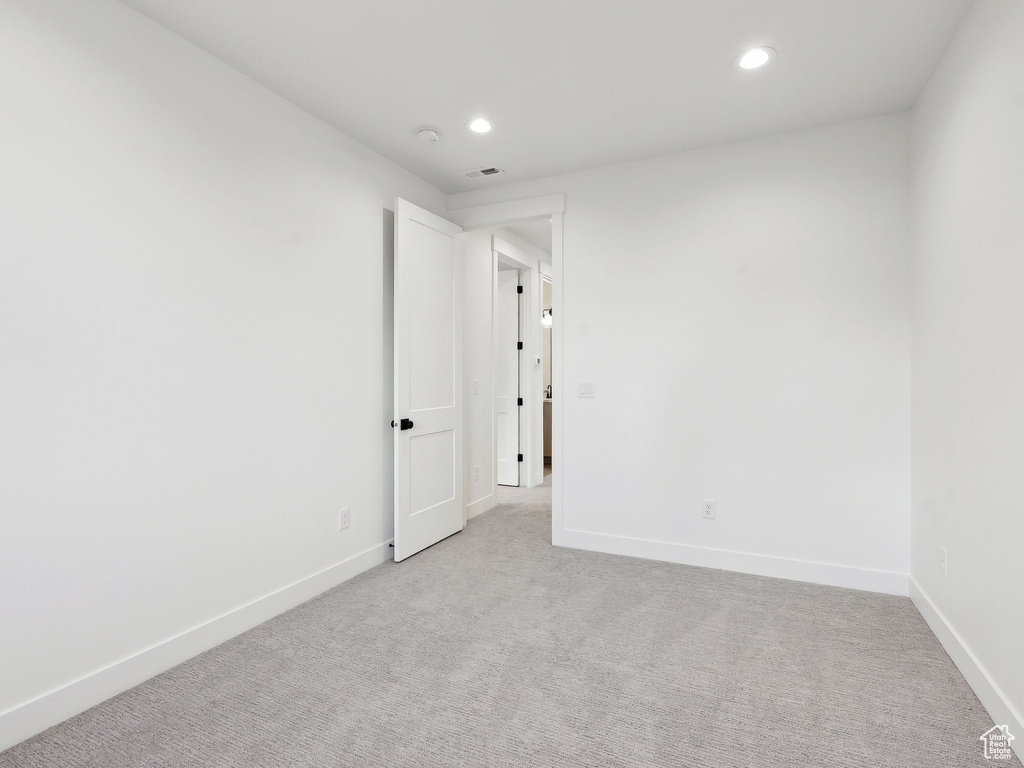 Unfurnished room featuring light colored carpet, recessed lighting, and baseboards
