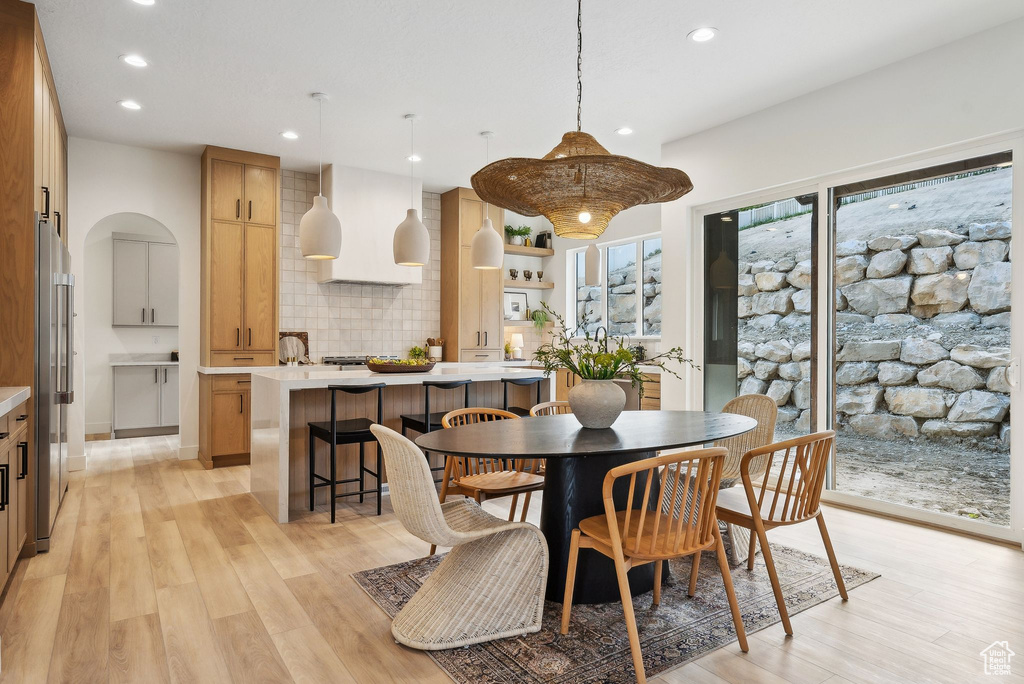 Dining area with recessed lighting and light wood-type flooring