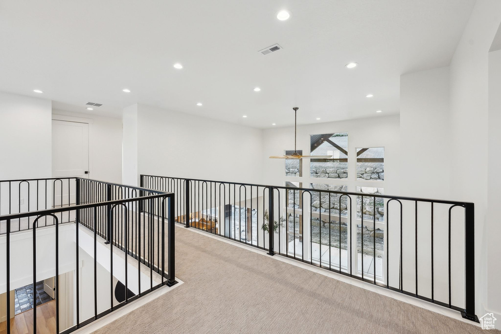 Hallway with recessed lighting, carpet flooring, and an upstairs landing