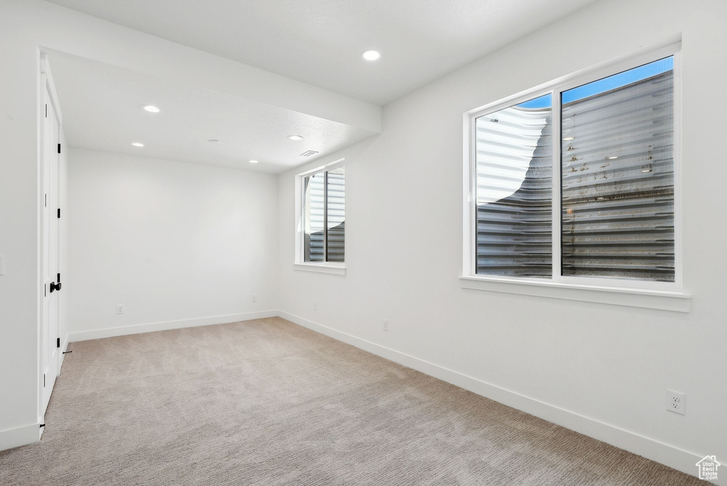 Unfurnished room featuring baseboards, light colored carpet, and recessed lighting