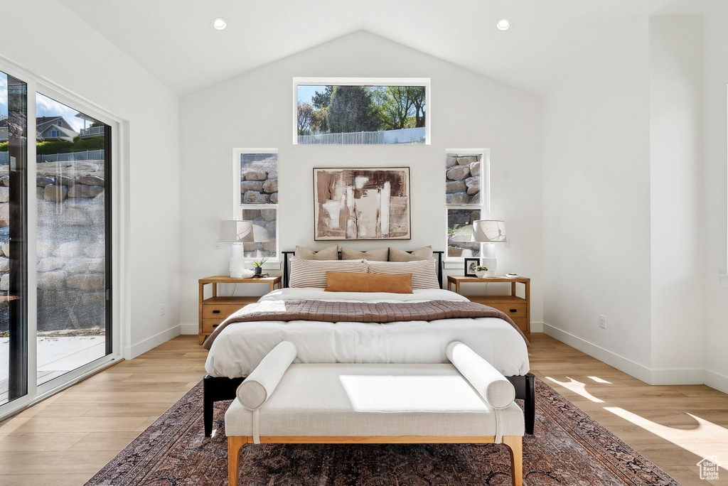 Bedroom with access to outside, lofted ceiling, light wood finished floors, baseboards, and recessed lighting