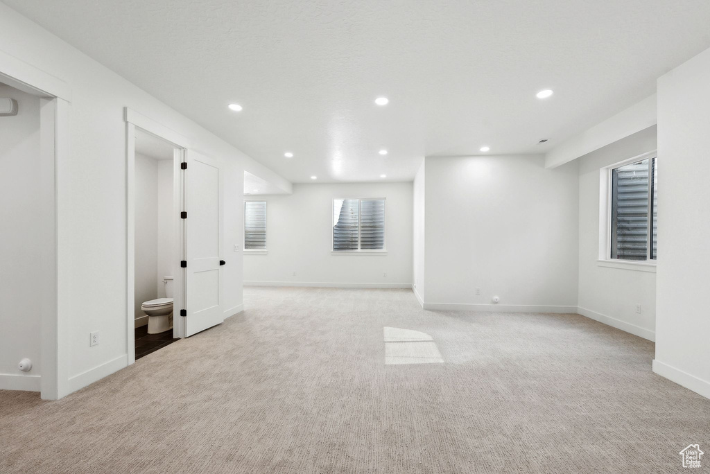 Below grade area with light carpet, recessed lighting, and baseboards