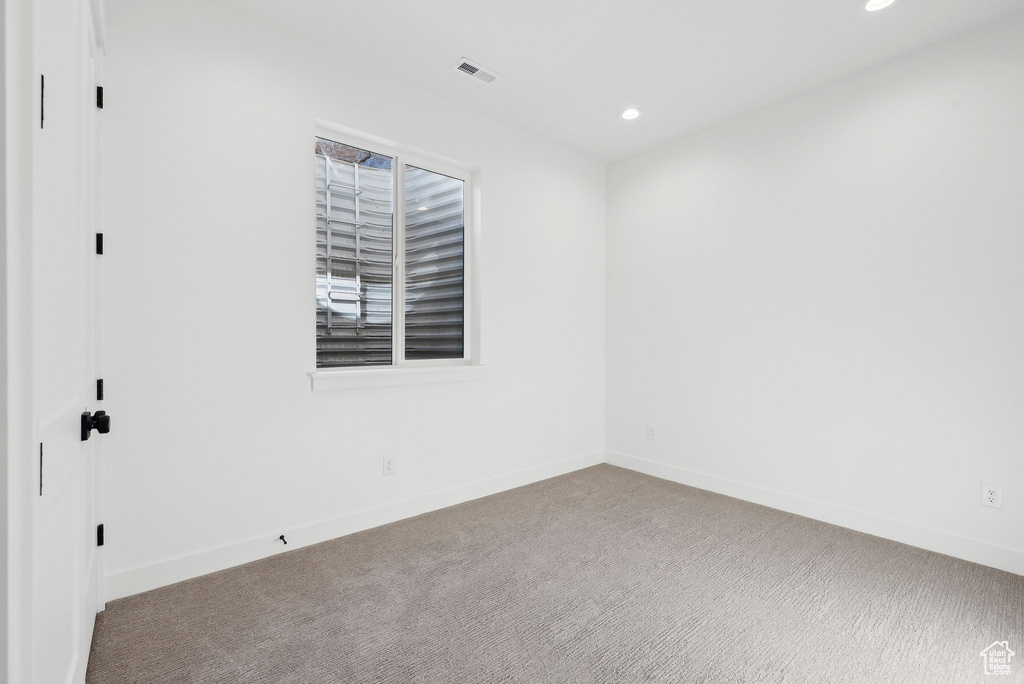 Carpeted empty room featuring recessed lighting and baseboards