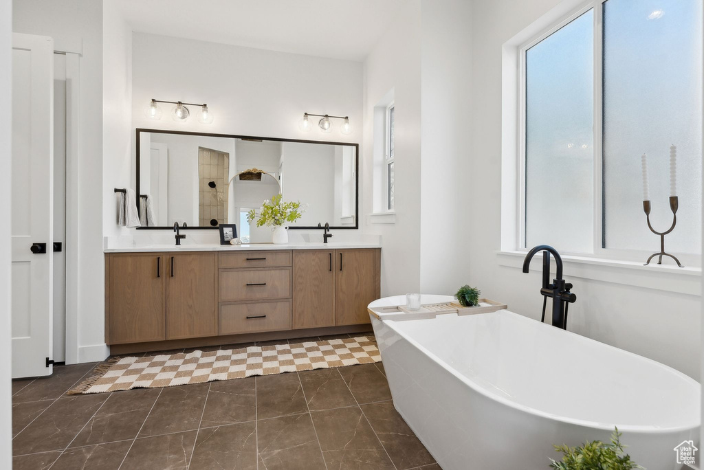 Full bath with plenty of natural light, double vanity, and a freestanding bath