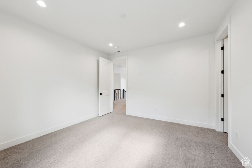 Empty room with recessed lighting, light colored carpet, and baseboards