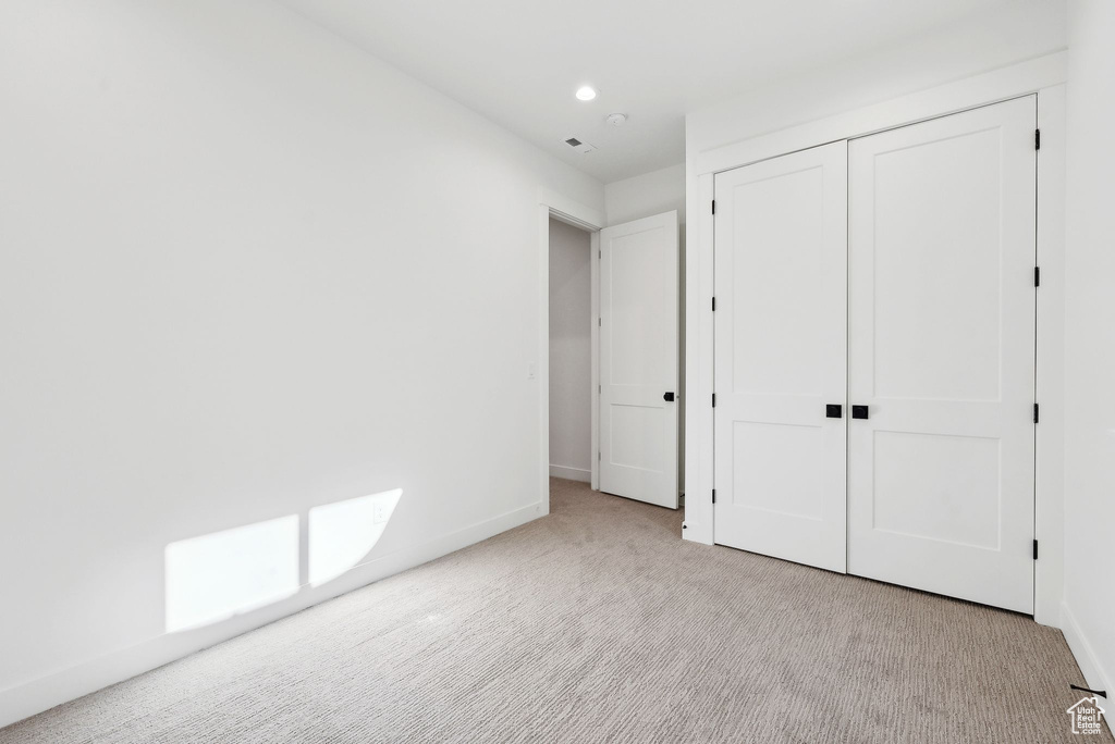 Unfurnished bedroom featuring carpet flooring, baseboards, a closet, and recessed lighting
