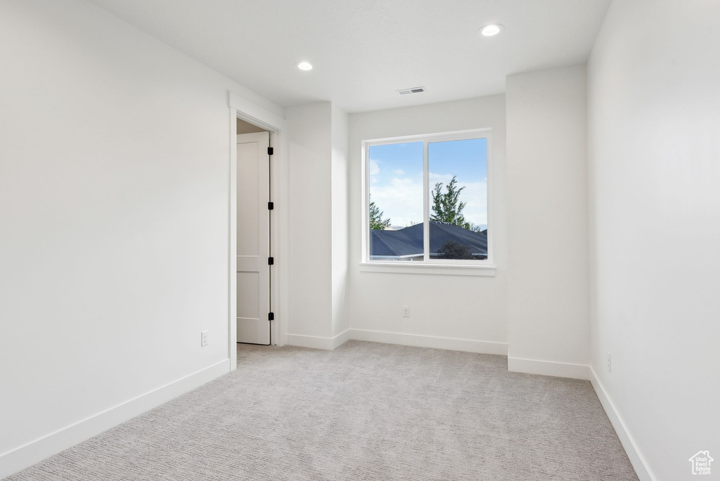 Spare room featuring light carpet, recessed lighting, and baseboards