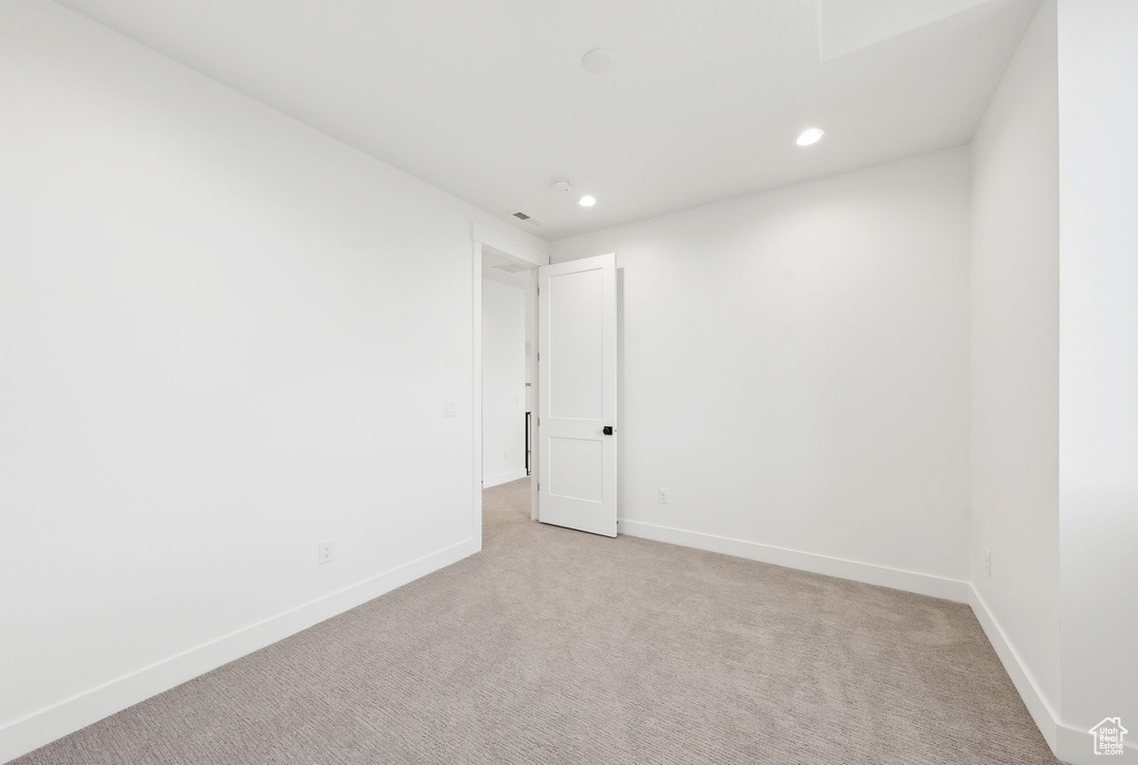Spare room with light colored carpet, recessed lighting, and baseboards