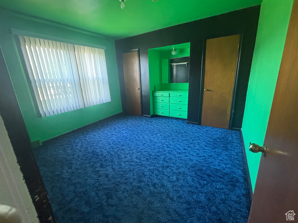 Unfurnished bedroom featuring carpet floors and baseboards
