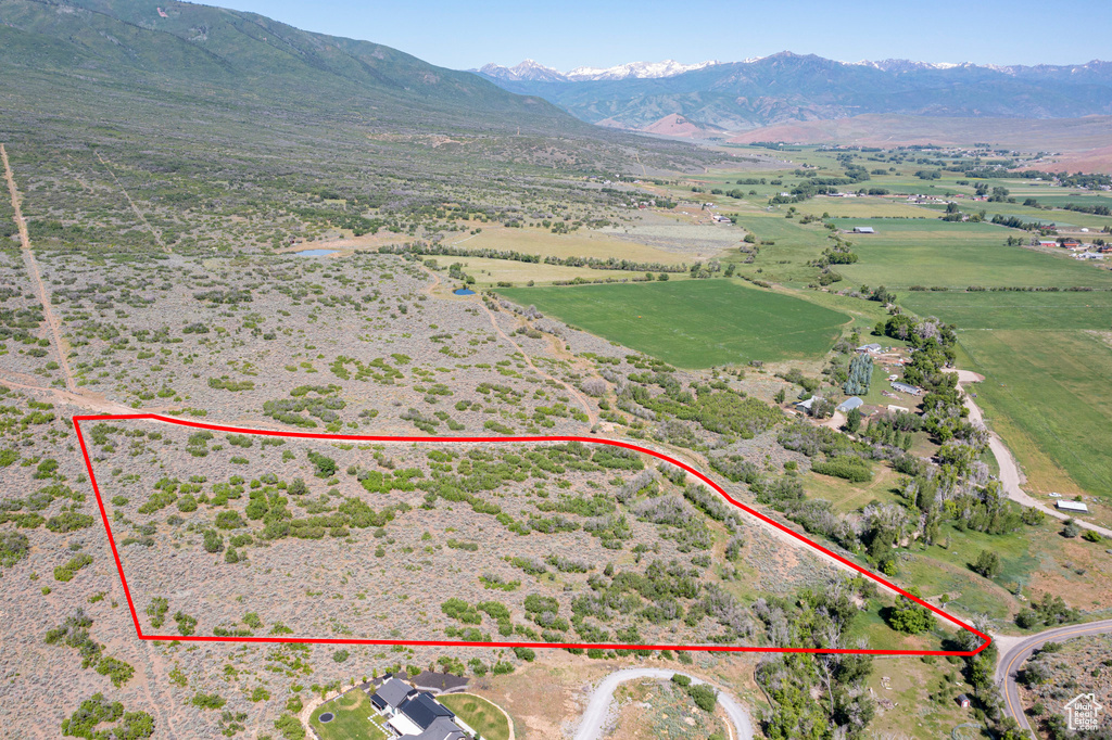 Overview of rural landscape with property parcel outlined and a mountainous background