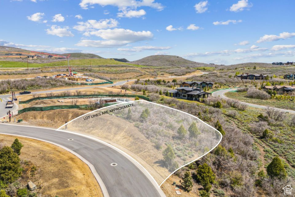 Aerial view of property's location with a mountainous background and property boundaries highlighted