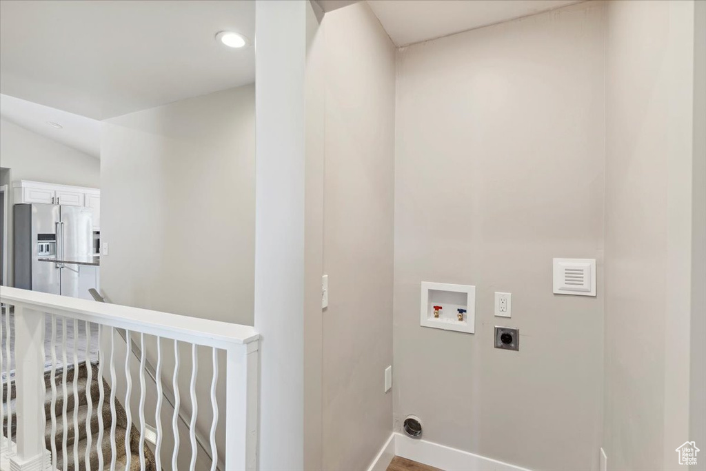 Washroom with electric dryer hookup, hookup for a washing machine, baseboards, and recessed lighting