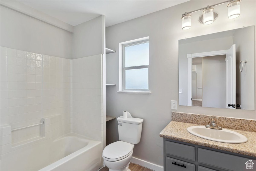 Full bathroom featuring toilet, vanity, shower / washtub combination, and baseboards