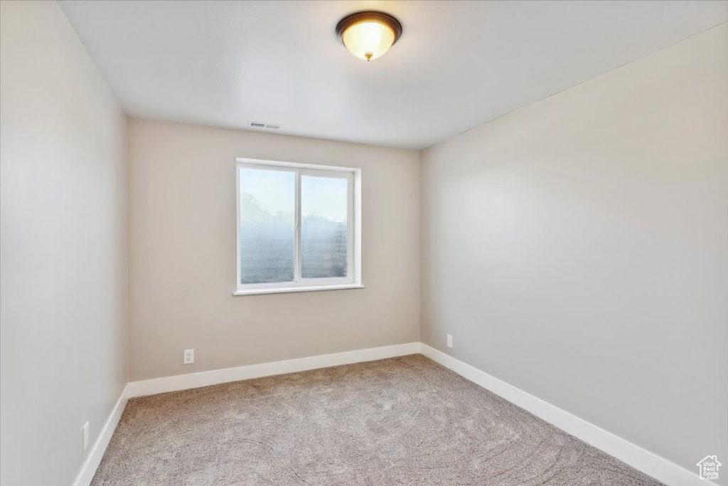 Carpeted empty room with baseboards