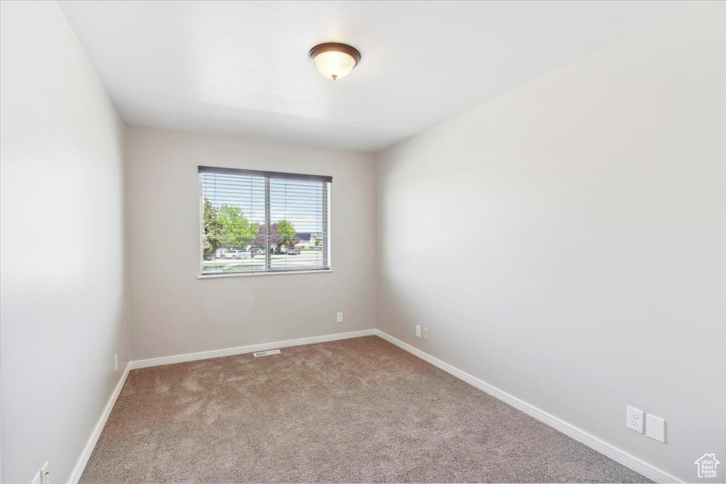 Empty room featuring carpet flooring and baseboards