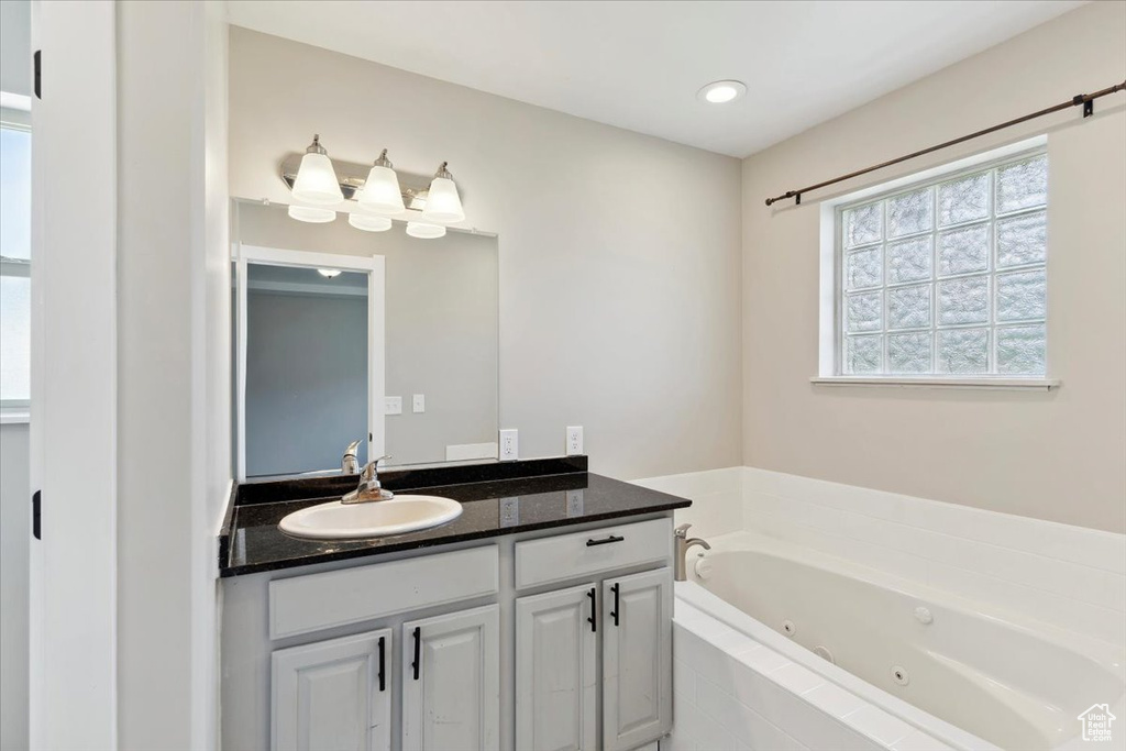 Full bath with a jetted tub and vanity