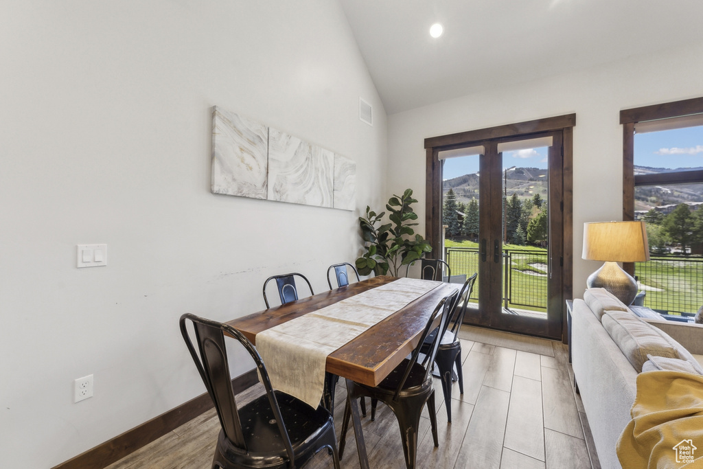 Dining space with french doors, plenty of natural light, and high vaulted ceiling