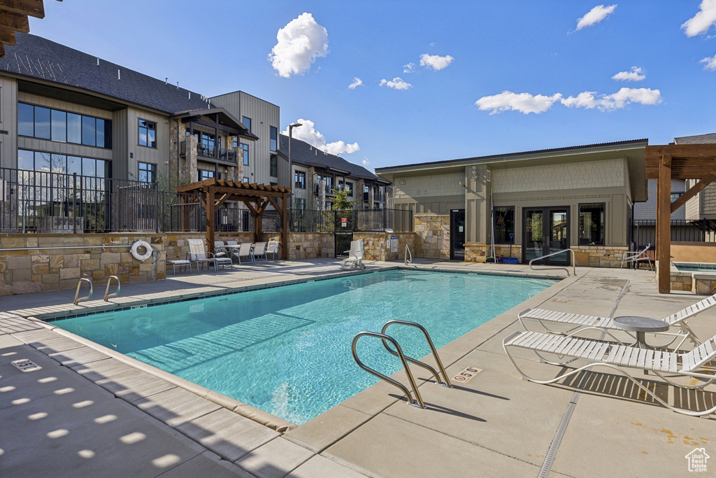 Community pool featuring fence, a pergola, a patio area, and a hot tub