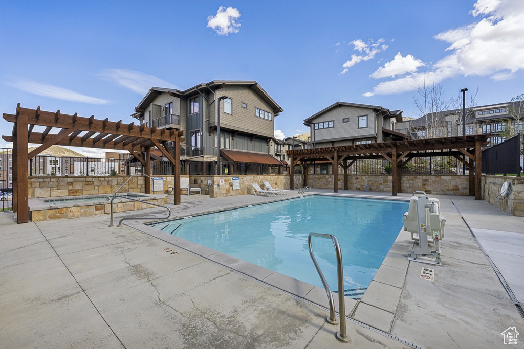 Community pool with a pergola, a patio, and fence
