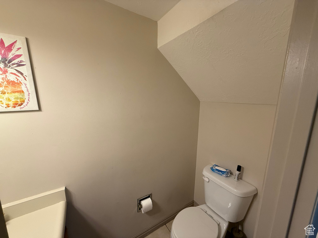 Bathroom with lofted ceiling and toilet