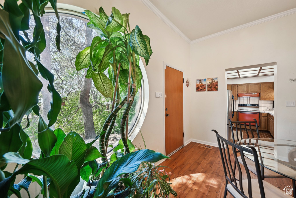 Entrance foyer with crown molding, dark wood finished floors, and baseboards
