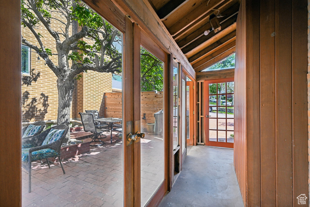 Entryway featuring french doors, lofted ceiling, and wood walls