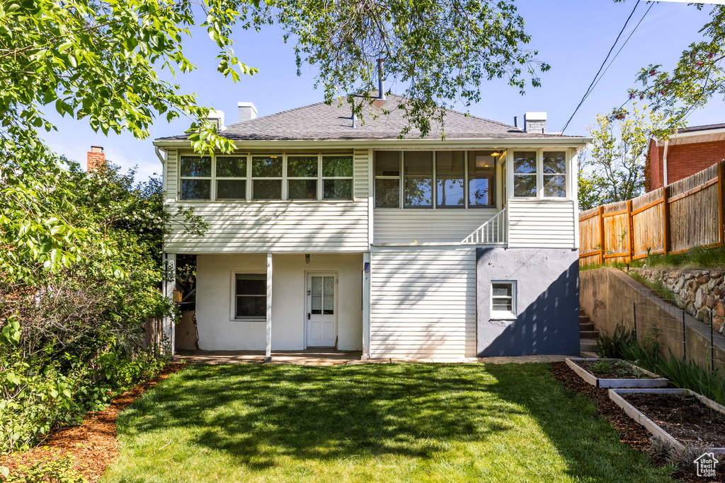 Back of house featuring a chimney, stucco siding, and a vegetable garden