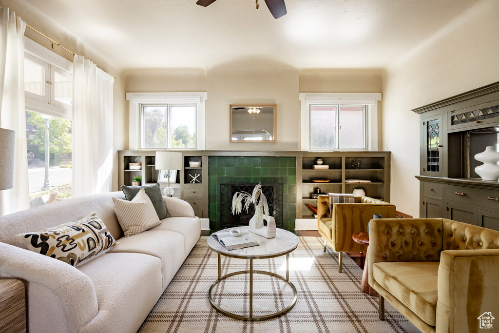 Living room with a fireplace, plenty of natural light, and ceiling fan
