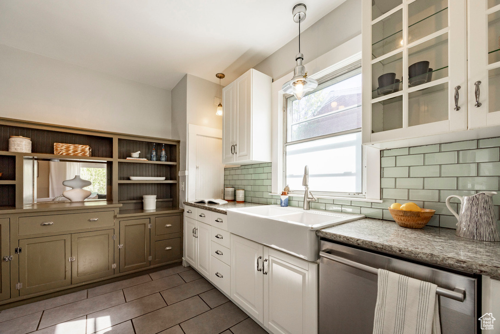 Kitchen with dishwasher, tile patterned flooring, pendant lighting, backsplash, and a sink