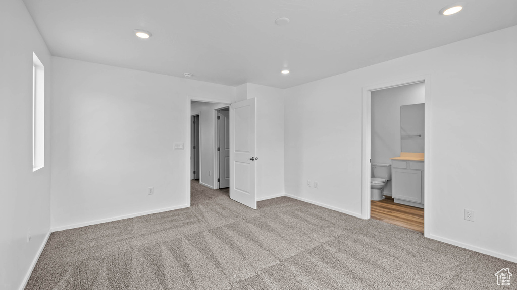 Unfurnished bedroom with carpet flooring, recessed lighting, baseboards, and ensuite bathroom