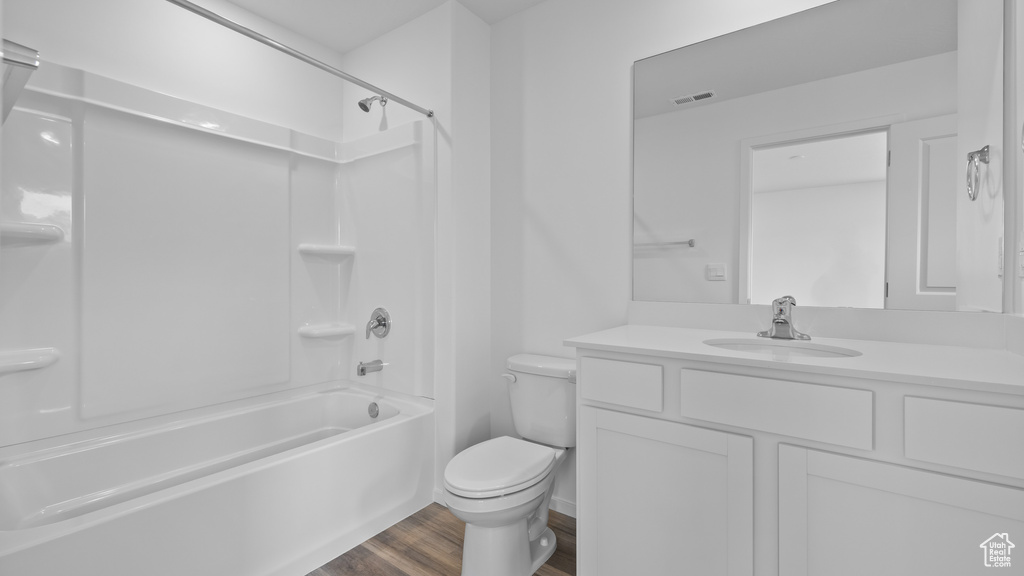 Full bathroom with toilet, wood finished floors, vanity, and tub / shower combination