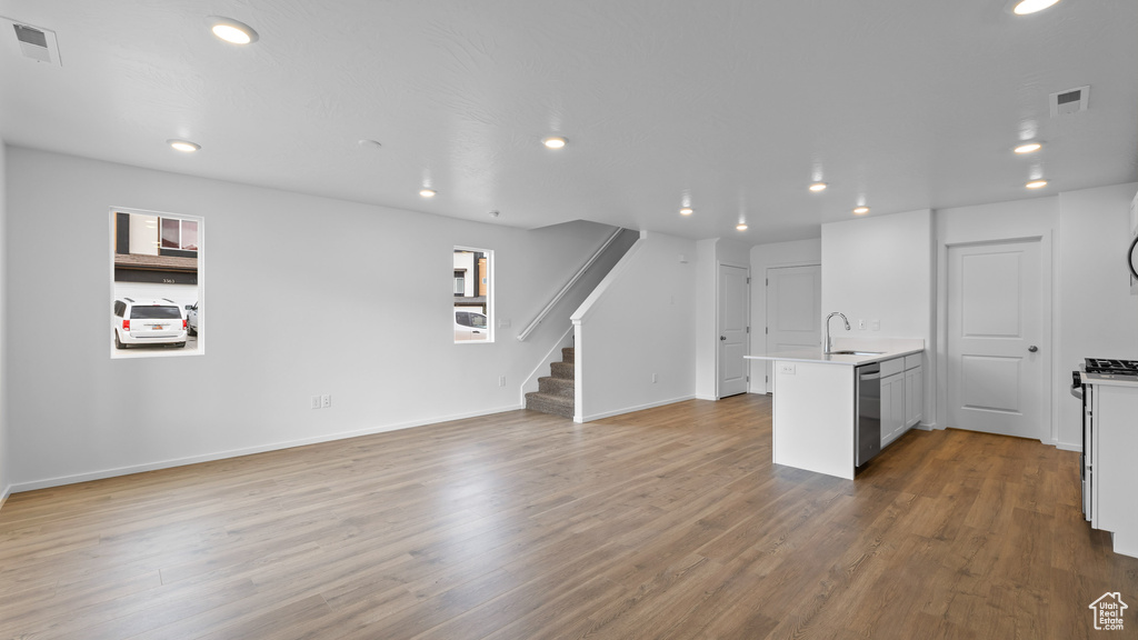 Kitchen with a peninsula, a sink, open floor plan, stainless steel dishwasher, and recessed lighting