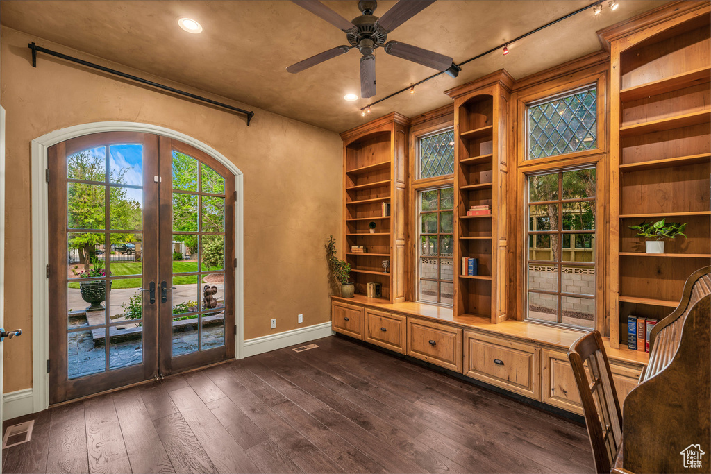 Unfurnished room featuring french doors, dark wood-style flooring, ceiling fan, and built in features