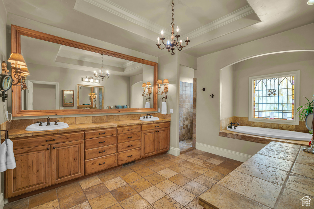 Full bath with a raised ceiling, a chandelier, stone tile flooring, crown molding, and baseboards