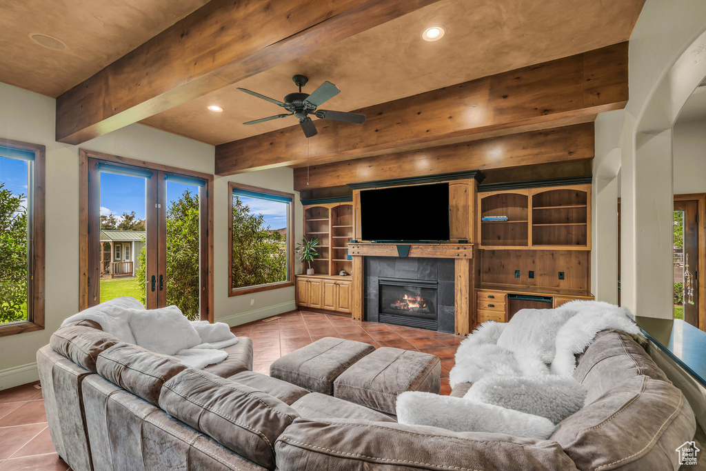 Living room with light tile patterned floors, baseboards, recessed lighting, beamed ceiling, and a tile fireplace