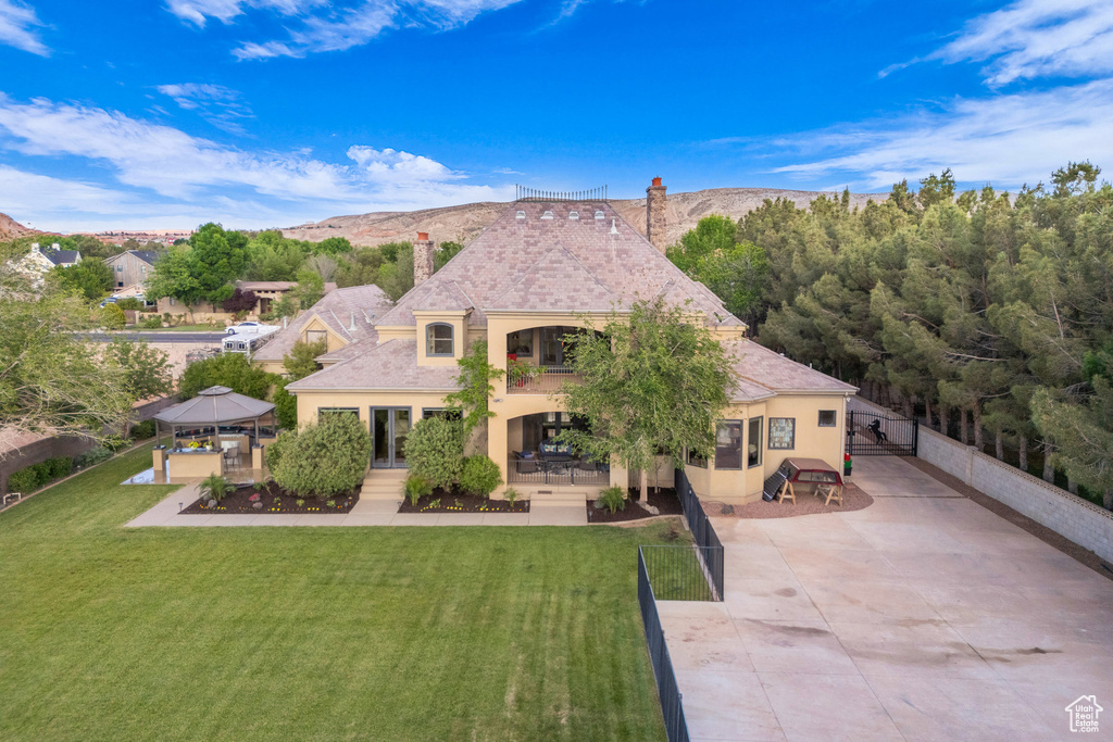 View of front of home with a gazebo, a chimney, stucco siding, a patio, and a mountain view