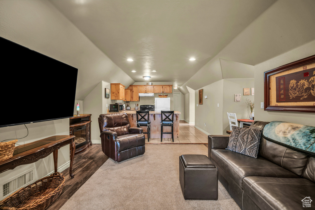 Living area featuring baseboards, vaulted ceiling, and recessed lighting