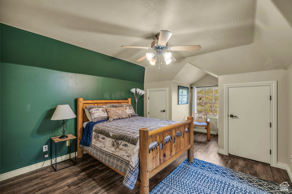 Bedroom featuring baseboards, wood finished floors, vaulted ceiling, and ceiling fan
