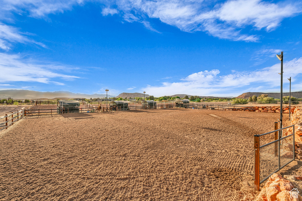 View of yard featuring an outdoor riding arena, a mountain view, a view of rural / pastoral area, and an exterior structure