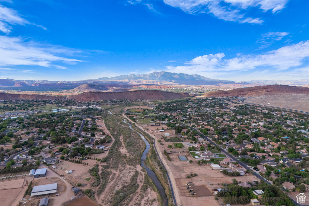 Aerial view of property and surrounding area with a mountainous background