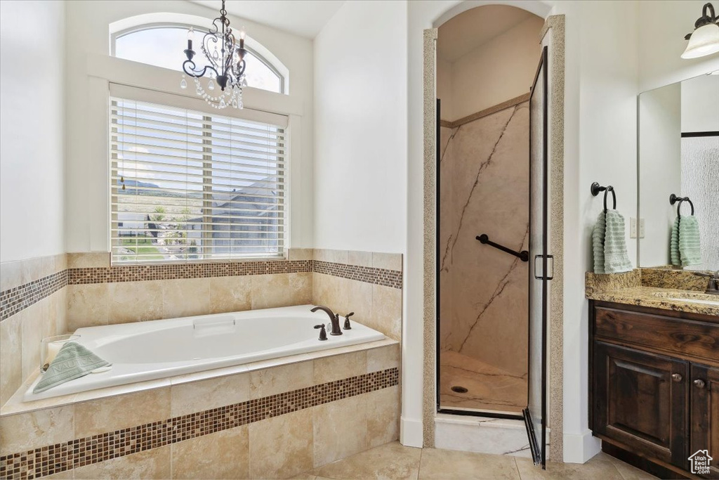 Full bath featuring a shower stall, a bath, a chandelier, vanity, and tile patterned flooring