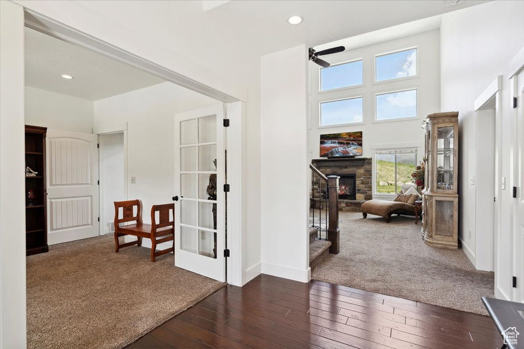 Corridor with dark wood-style floors, recessed lighting, baseboards, dark carpet, and french doors