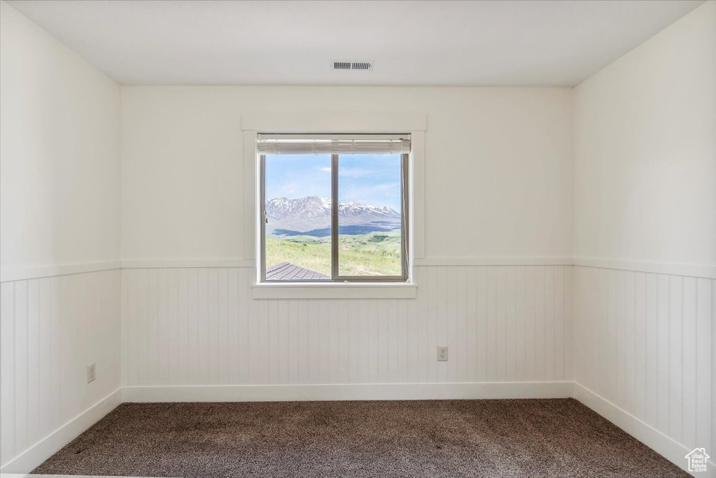 Carpeted empty room with wainscoting and baseboards