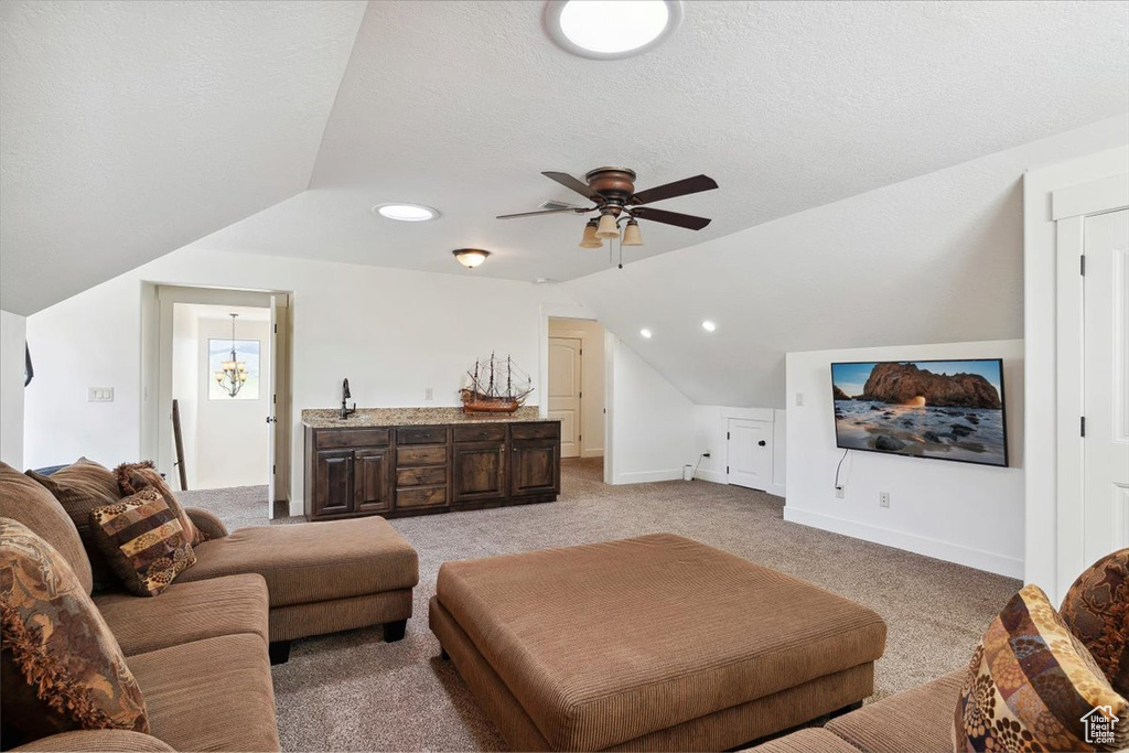 Living area featuring lofted ceiling, light carpet, a ceiling fan, baseboards, and recessed lighting