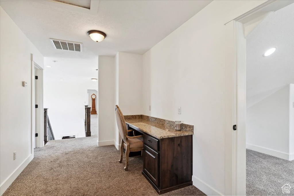 Carpeted office space with baseboards