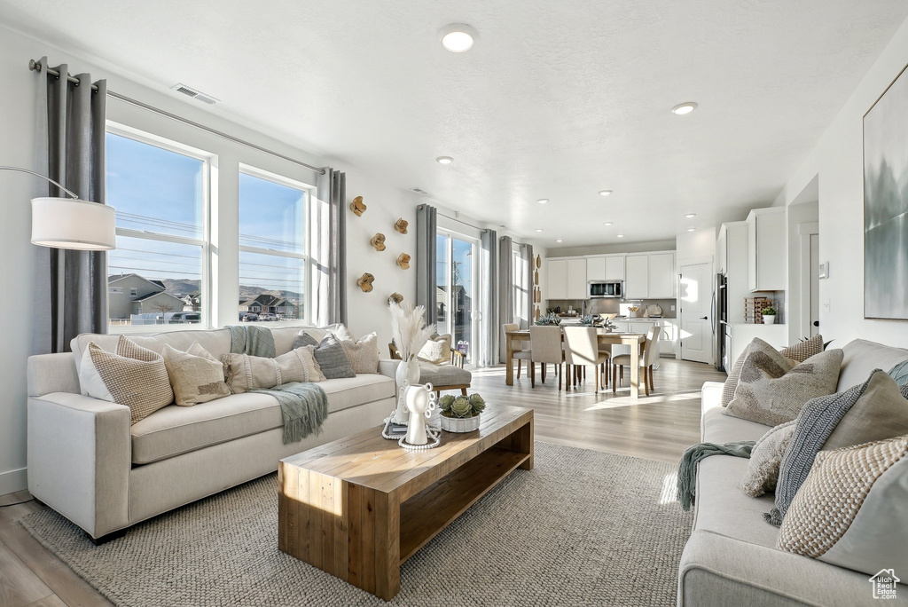 Living area featuring light wood finished floors and recessed lighting