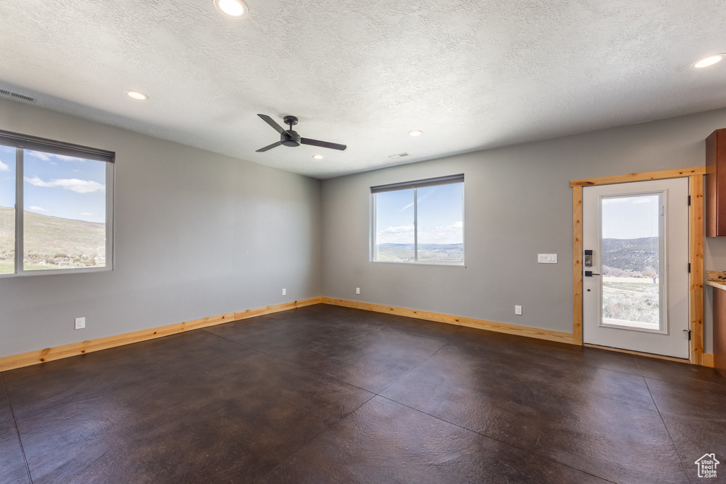 Unfurnished room featuring baseboards, recessed lighting, a textured ceiling, ceiling fan, and finished concrete flooring